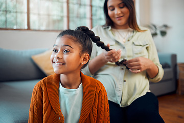 Image showing Mom, girl and hair care in living room for bonding, love and care by sofa with happiness in home. Hair, mother and daughter for hairdresser, pony tail or helping hand with grooming for kid in Atlanta