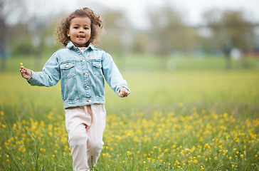 Image showing Girl child, field and flower on walk in nature park, garden or backyard for happiness, playing and relax. Young female kid, walking with wild flowers, natural plants or outdoor by trees, grass or sun