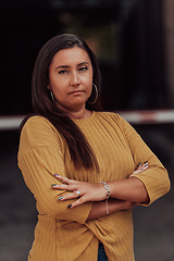 Image showing A powerful portrait of a businesswoman, standing confidently with her arms crossed, representing the determination of the female gender and embodying strength and success