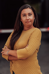 Image showing A powerful portrait of a businesswoman, standing confidently with her arms crossed, representing the determination of the female gender and embodying strength and success