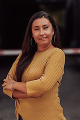 Image showing A powerful portrait of a businesswoman, standing confidently with her arms crossed, representing the determination of the female gender and embodying strength and success