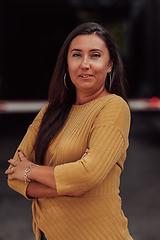 Image showing A powerful portrait of a businesswoman, standing confidently with her arms crossed, representing the determination of the female gender and embodying strength and success