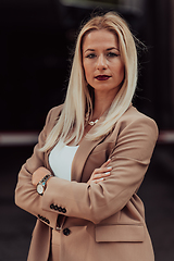 Image showing A powerful portrait of a businesswoman, standing confidently with her arms crossed, representing the determination of the female gender and embodying strength and success