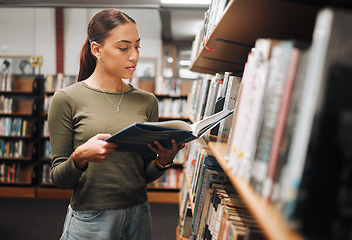 Image showing Black woman reading book in a library for education, studying and research in school, university or college campus. Focus, book and student at bookshelf for language learning or philosophy knowledge