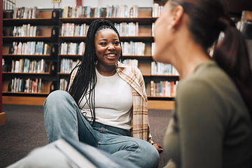 Image showing University, students and friends on library floor for studying, education and learning together. Happy black girl, gen z youth and college student at academy, campus and school in room with bookshelf