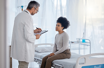 Image showing Healthcare, doctor and woman consulting for insurance, documents and consent form in hospital bed. Medical, consultation and black woman with doc checklist, life insurance and permission for surgery