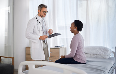 Image showing Consulting, medical and doctor with black woman in hospital for checklist, examination and therapy. Appointment, interview and help with healthcare worker listening to patient for physician checkup