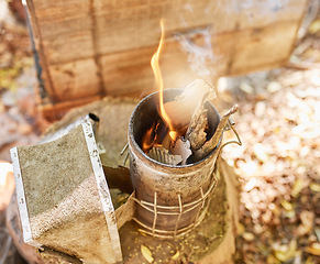 Image showing Smoke, fire and metal container on bee farm for agriculture, smoking and honey production. Farming, vintage and beekeeping with flame in smoker to calm bees for safety, protection and preparation