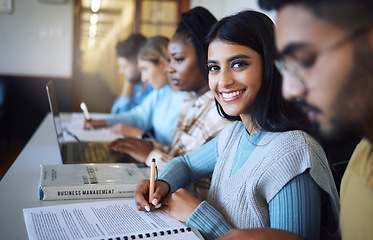 Image showing College student writing notes for business management in classroom, course and campus. Portrait, young indian girl and university student happy for learning, education and studying at finance academy