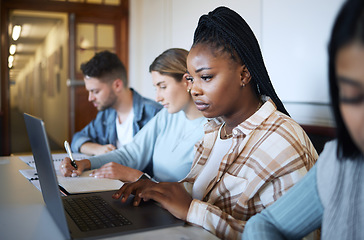 Image showing University, education and group of students at desk doing project, studying and learning with laptop and notebook. Academy, college and young people taking notes in classroom, study group and lecture