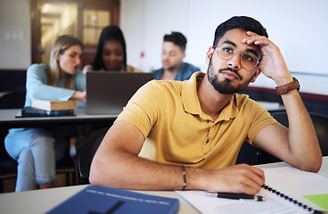 Image showing Indian man, student and bored in classroom, tired and stress with notes, examination or task. Young male, guy or exhausted for education, test or notes for assignment with headache and depressed