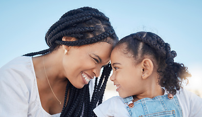 Image showing Family, outdoor and love of a mother and daughter together for fun at a park while touching heads with a smile, happiness and care during travel. Black woman and child against blue sky for freedom