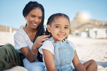 Image showing Happy girl portrait, hair care and mother on a beach on summer holiday with mom love and care. Hairstyle help, support and happiness of a mama with her child relax on vacation by the sea and ocean