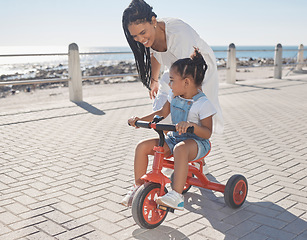 Image showing Summer, ocean and mother with girl on bicycle enjoying holiday, vacation and quality time together on weekend. Family, love and mom with young child on bike for support, freedom and adventure by sea