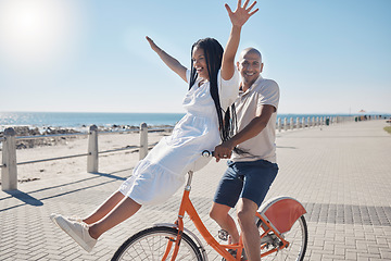 Image showing Bicycle, beach and couple with freedom, travel and summer holiday in city sidewalk for wellness, love and care in sunshine. Mental health, black woman and cycling partner at ocean on blue sky mockup