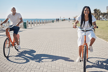 Image showing Travel, summer and couple on bike at beach for date on promenade in Chicago, USA sunshine with smile. Freedom, fun and happy black people at ocean with bicycle for wellness, bonding and fitness.