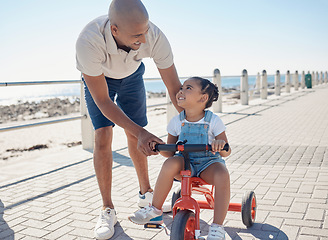 Image showing Father, girl child and tricycle at park, learning and happy in ocean sunshine on family vacation. Dad, daughter and happiness by sea promenade, teaching and smile on seaside holiday in San Francisco