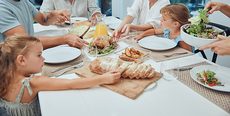 Image showing Big family, food and lunch at table in home, eating and bonding. Fine dining, bread and father, mother and grandparents with girls sharing a delicious, gourmet and healthy meal together in house.