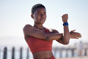 Image showing Fitness, exercise and black woman stretching in city for healthy lifestyle, wellness and cardio workout. Sports, motivation and female athlete ready to start running, marathon training and jog by sea