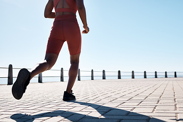 Image showing Running, legs and promenade with a sports woman or runner outdoor for an exercise with blue sky mockup. Fitness, workout and shoes with a female athlete taking a run for cardio or endurance training