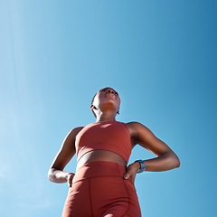 Image showing Low angle, sports fitness and black woman outdoor getting ready for workout, training or exercise with mock up. Blue sky, health and female runner thinking of exercising, cardio or jog for wellness.