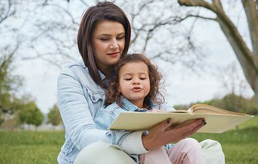 Image showing Nature, mother and child reading book in park, story time in park or garden on summer weekend. Storytelling, books and love, mom teaching girl to read sitting on grass in backyard and relax together.