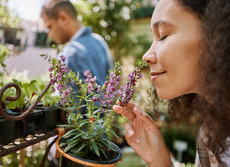 Image showing Smelling, plants and face of a woman at a nursery, flower shopping and aroma at a garden market. Happy, peace and girl with smell of flowers, pot plant and floral heather ecology at a gardening shop