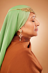 Image showing Muslim, culture clothes and senior woman with jewelry, faith and hijab against a brown studio background. Islamic fashion, traditional and modest burka model with religion, spiritual and scarf