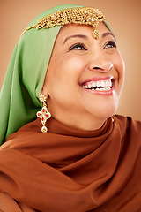 Image showing Fashion, beauty and muslim woman with culture jewelry and head scarf posing with a smile in a studio. Tradition, arabic and mature indian lady with hijab and jewellery isolated by a brown background.