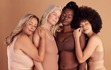 Image showing Support, diversity and women with hug for body positive marketing, solidarity and advertising underwear on a studio background. Collaboration, affection and model friends hugging for empowerment