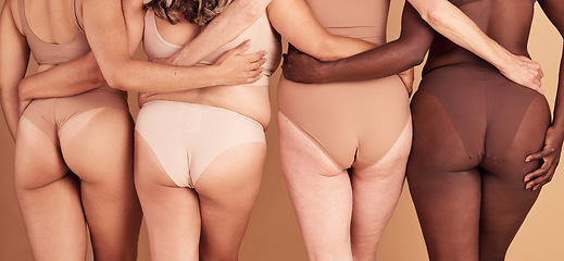 Image showing Self love, diversity and women underwear group for skin color inclusivity panties campaign back view. Body positive, plus size and interracial people hug together on beige studio background.