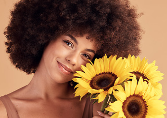 Image showing Skincare, natural and black woman portrait with sunflower bouquet for afro hair care, beauty and cosmetic campaign. Smile of beautiful model with healthy skin and hair texture in beige studio.