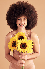 Image showing Beauty, skincare and black woman with sunflower, smile and natural hair on a studio background for cosmetics, makeup and self love. Portrait afro female with flowers for spring dermatology and glow