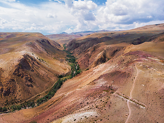 Image showing Aerial shot of the textured yellow nad red mountains resembling the surface of Mars