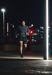 Image showing Running, fitness and man in night city for training muscle, body goals and lose weight challenge in motivation, energy and speed. Sports, athlete and cardio runner in the dark or urban street lights