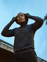 Image showing Fitness, health and man runner in a city for training, exercise and morning cardio against blue sky background. Sports, black man and relax before running, workout and marathon practice in London