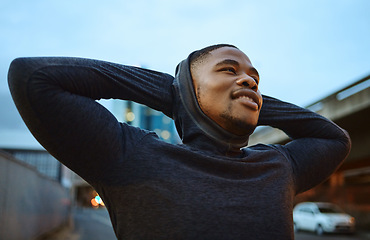 Image showing Running, fitness and city with a sports black man taking a rest during his exercise or workout in the evening. Training, health and break with a male runner or athlete in an urban town for cardio