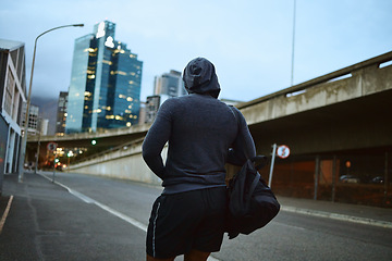 Image showing Fitness, running and city with a sports man walking on an asphalt road during an exercise workout. Health, wellness and training with a male runner or athlete in an urban town during the evening