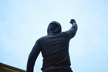 Image showing Success, fitness and man with fist on outdoor, blue sky mockup for workout goals, energy and winning in sports race competition. Rear of athlete with mock up for marketing of winner, power hand sign