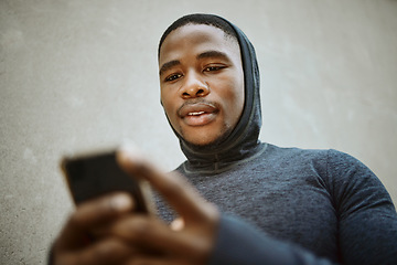 Image showing Fitness, black man and phone typing in city to check social media, internet or search mobile app, online sports blog and exercise tech. Young athlete reading notification on smartphone before workout