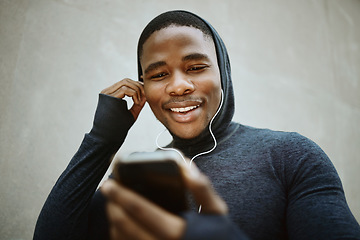 Image showing Music, phone and man against a wall in city for fitness, running and training with podcast, audio and wellness track. Radio, black man and smartphone for for listening to playlist before a workout