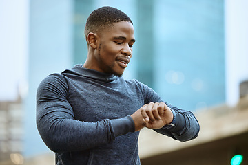 Image showing Fitness, black man and checking time in the city ready for exercise, workout or cardio training in the outdoors. Active man in sports looking at smart watch for heart monitoring, rate or performance