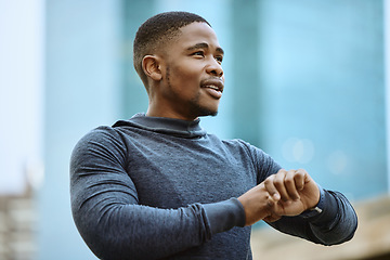 Image showing Running, fitness and watch with a sports black man checking his time while outdoor for a cardio run. City, thinking and goal with a male runner or athlete in a town for exercise or a workout