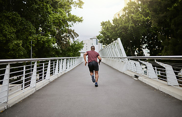 Image showing Fitness, man and running in the city park for healthy exercise, cardio workout or training in the outdoors. Active athletic male runner in sports activity, run or exercising outside on city bridge