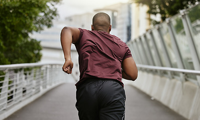 Image showing Back, black man and running outdoor, workout and training for marathon, wellness and health. African American male, athlete and runner practice on street, fitness and exercise for energy and cardio.