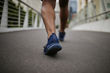 Image showing Fitness, legs or runner walking on a city bridge in a warm for training, cardio exercise or calf muscle workout. Wellness, zoom or sports athlete trekking or exercising with running shoes or footwear