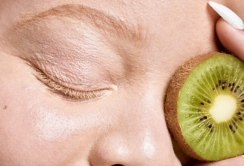 Image showing Woman, face and kiwi for eyes skincare glow or cosmetics dermatology and salon spa beauty wellness. Natural fruit detox, cosmetology nutrition and model facial care, luxury vitamin c and self care