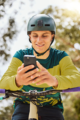 Image showing Mountain bike, phone and man outdoor in nature forest while online with a smile for communication or watching stunt video on internet. Athlete male with bicycle and smartphone for sports training