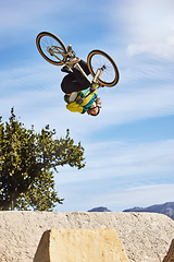 Image showing Cycling sports, bike and jump of man performing stunt outdoors in nature. Trick, dangerous risk and biker, rider or bmx athlete on bicycle jumping on ramp for training exercise, workout and fitness