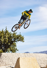 Image showing Man, cyclist and mountain biking in free style, tricks or extreme hill jumping in the nature outdoors. Professional male cycling in the mountain with bicycle in the air for freedom, parkour or sports